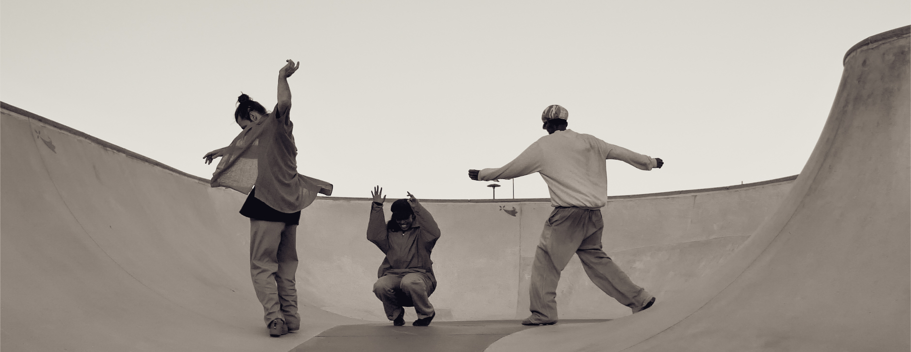 Trois danseurs et danseuses en improvisation sur les pentes d'un skatepark