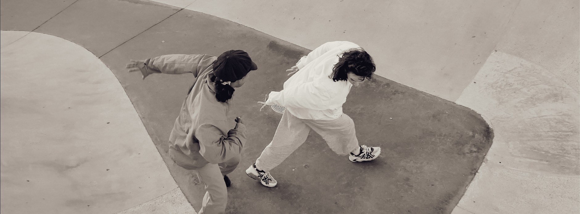 Deux danseuses vues de dessus, se faisant face sur le béton d'un skatepark